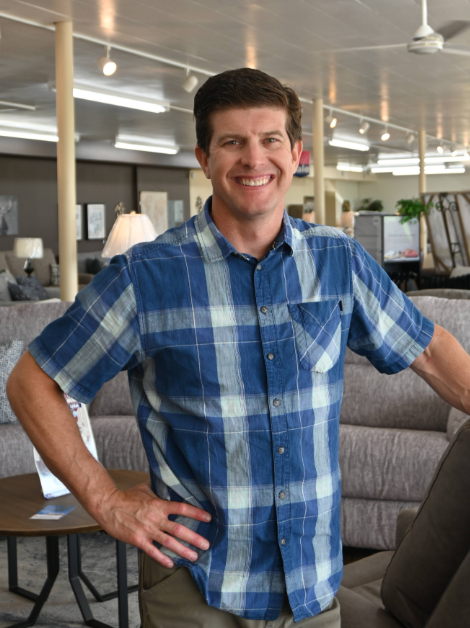 Meyers family member standing confidently in the showroom, surrounded by sofas and living room displays.