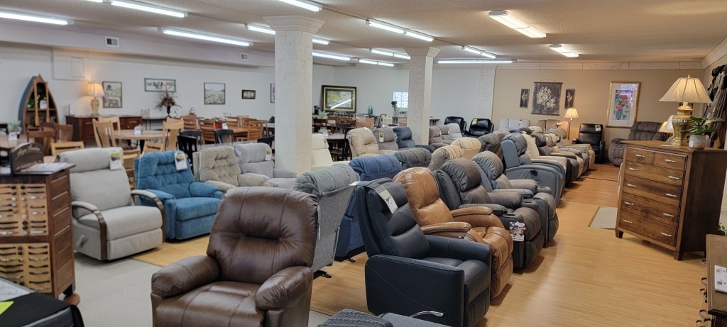 Large selection of recliners displayed in the Meyers Furniture Rochelle showroom, featuring leather, fabric, and power recliner styles in multiple colors.