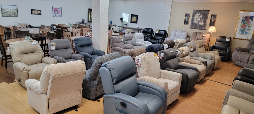 Rows of fabric recliners in neutral and blue tones on display at the Meyers Furniture Rochelle store.