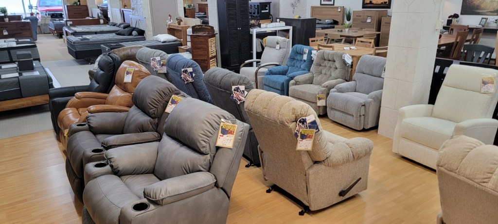Extensive lineup of recliners in various fabrics and colors on the showroom floor at Meyers Furniture in Rochelle.